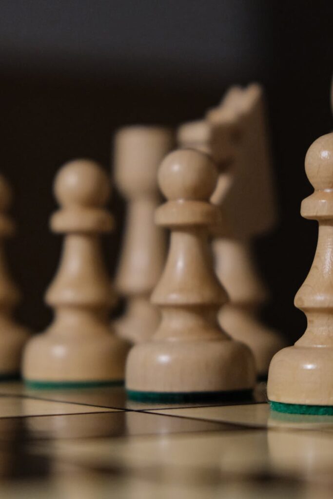 Close-up of chess pieces on board, highlighting pawns in strategic arrangement.